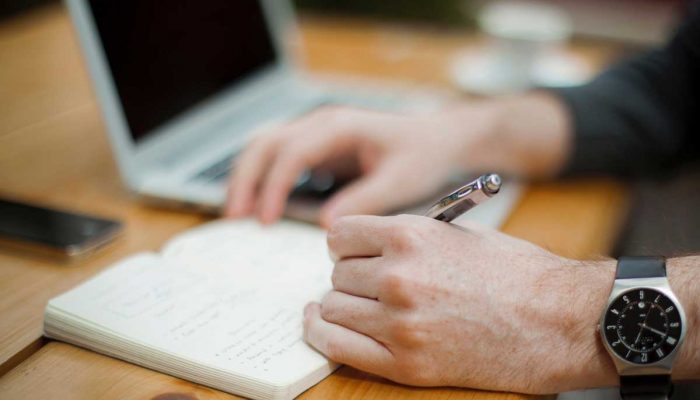 Persona tomando notas en una libreta